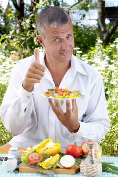 De man de vegetarische salade smaakt — Stockfoto