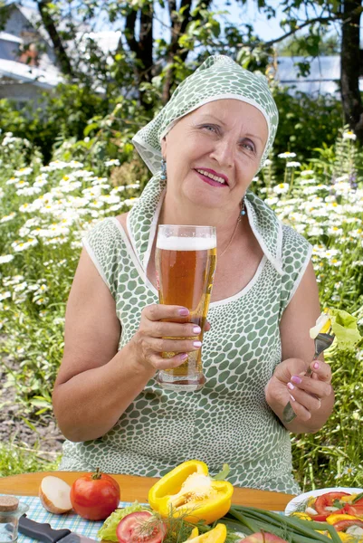 Yetişkin kadın taze soğutulmuş karanlık arpa bira içiyor. — Stok fotoğraf