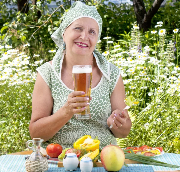 The adult woman drinks the fresh cooled dark barley beer — Stock Photo, Image
