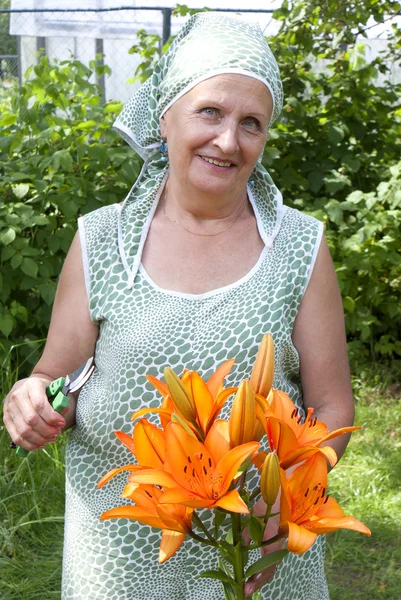 Die glückliche Frau engagiert sich in der Blumenzucht — Stockfoto