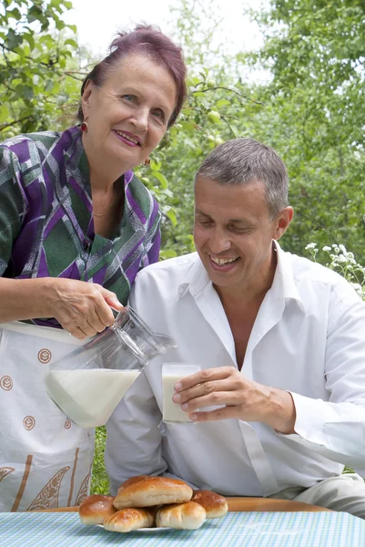 Счастливая семья ест домашние пироги со свежим молоком — стоковое фото