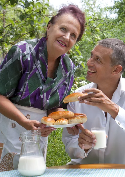 Die glückliche Familie isst gebackene Hauskuchen mit frischer Milch — Stockfoto