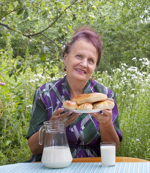 Yetişkin kadın ve iştah açıcı pişmiş ev pastaları — Stok fotoğraf