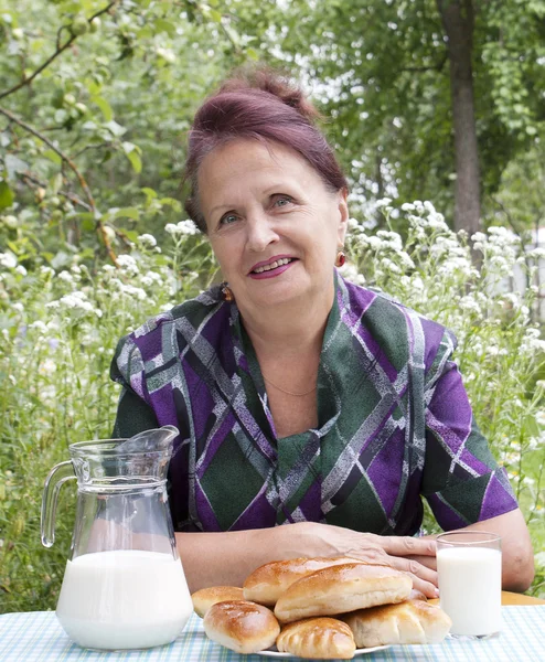 La hembra adulta y apetitosos pasteles de casa horneados con leche fresca — Foto de Stock