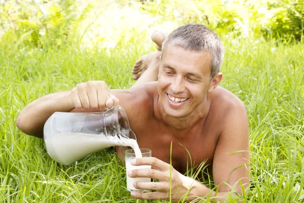 O homem adulto feliz bebe leite fresco — Fotografia de Stock