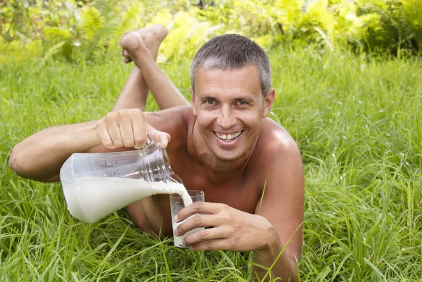 The happy adult man drinks fresh milk — Stock Photo, Image