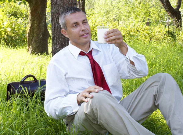 stock image The happy businessman drinks fresh milk