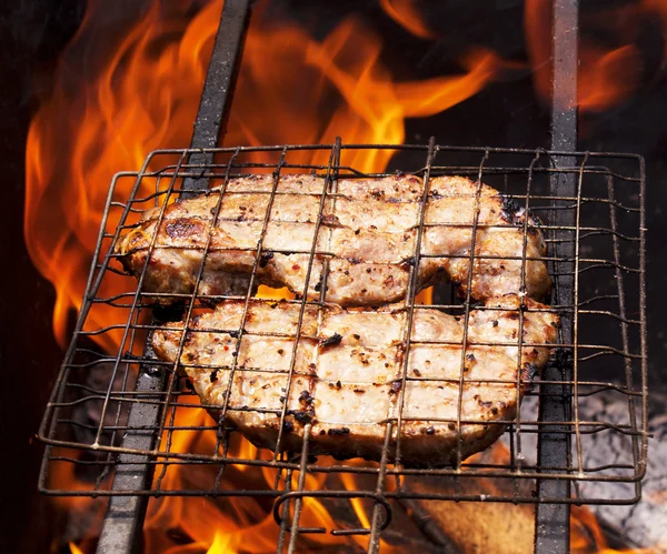 Аппетитное барбекю против огня — стоковое фото