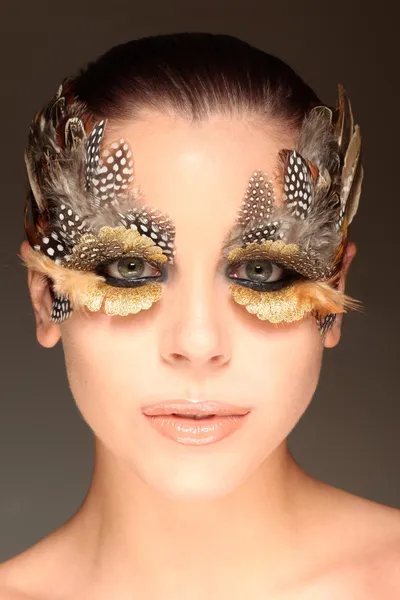 Femme portant des plumes créatives maquillage — Photo