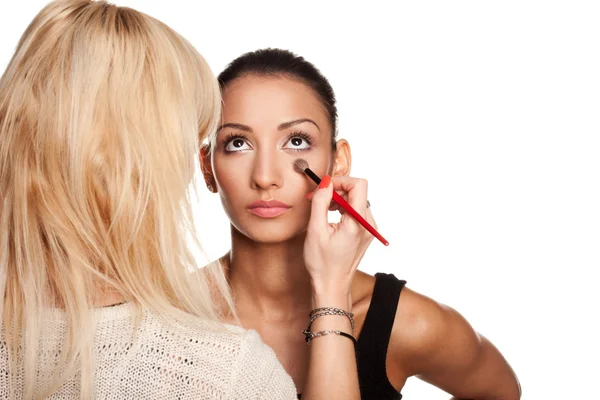 Maquiagem artista aplicando maquiagem ao seu modelo — Fotografia de Stock