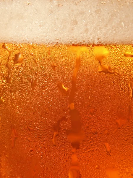 Cerveza con espuma en vidrio fresco tomada de cerca . — Foto de Stock