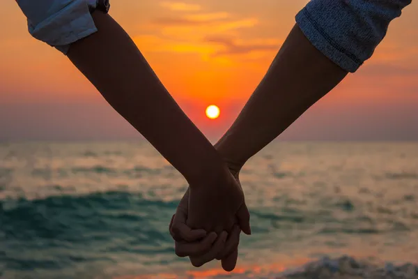 Couple tenant les mains en mer Coucher de soleil — Photo