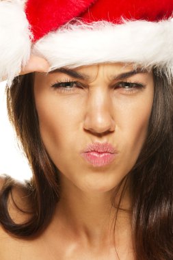 Beautiful woman wearing santas hat looking angry clipart