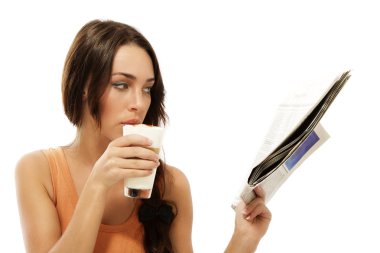 Beautiful woman drinking latte macchiato coffee reading newspaper clipart