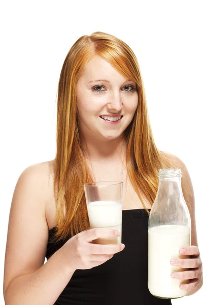 Молодая рыжая женщина со стаканом и бутылкой с молоком — стоковое фото