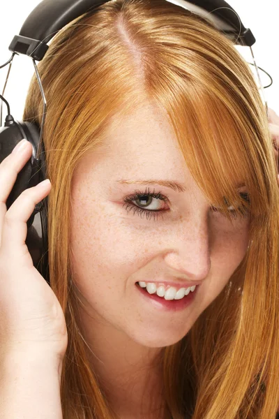 Young redhead woman listening to music — Stock Photo, Image