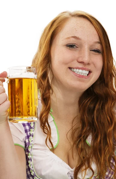 Jeune femme en robe bavaroise montrant un verre avec bière — Photo
