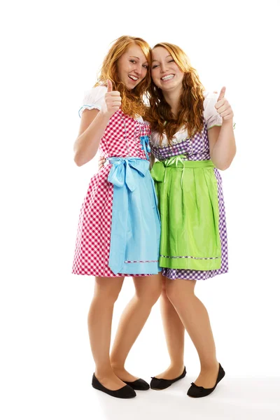 Two happy bavarian dressed girls showing thumbs up — Stock Photo, Image