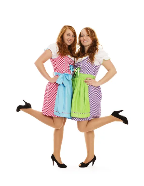 Two bavarian dressed girls lifting their feet — Stok fotoğraf