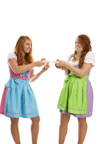 Két bajor öltözött lányok húzza a borjúhús-kolbász — Stock Fotó