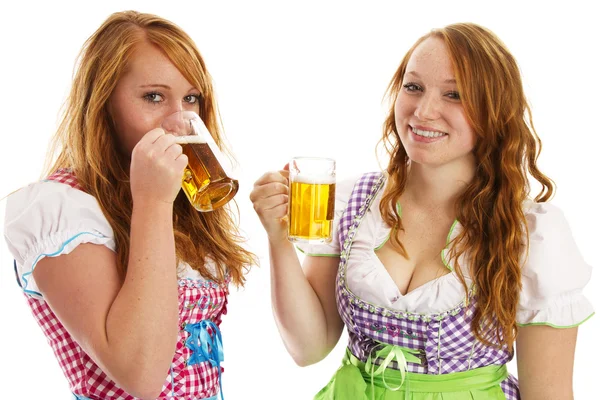 สาวบาวาเรียสองคนหัวเราะและดื่มเบียร์ — ภาพถ่ายสต็อก