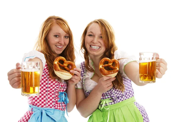 Two bavarian girls with pretzels cheering with beer — Stock Photo, Image