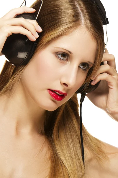 Jeune femme blonde avec écouteurs écoutant de la musique — Photo