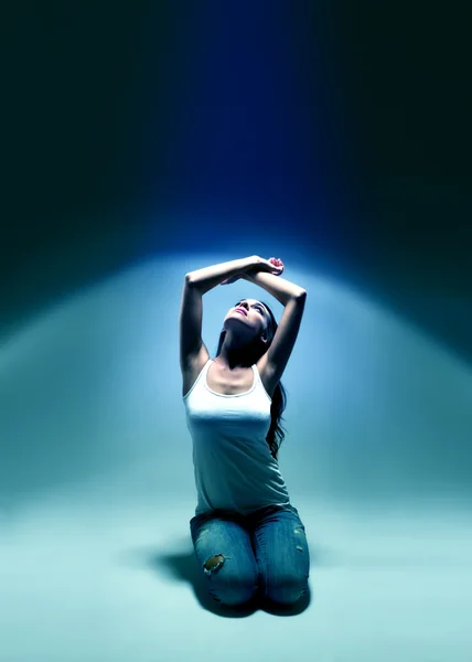 Молодая женщина смотрит вверх в голубой свет — стоковое фото
