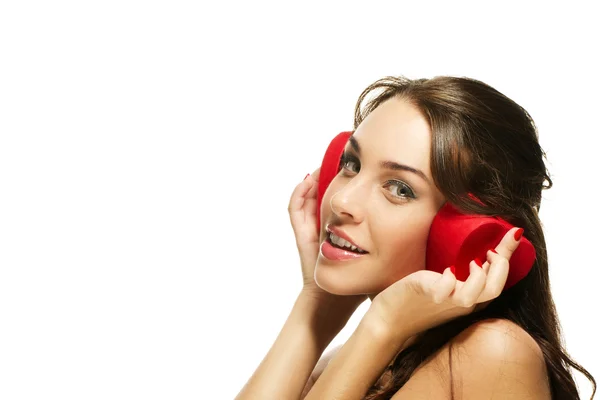 Bella donna felice tenendo scatola a forma di cuore rosso sulle orecchie — Foto Stock