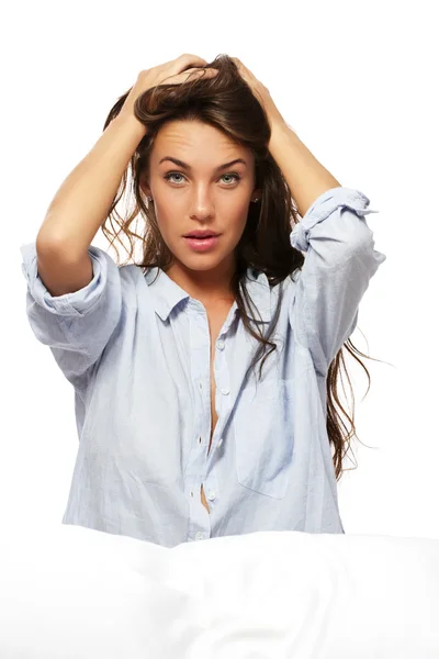 Vrouw in pyjama's zitten in bed houden haar haren — Stockfoto