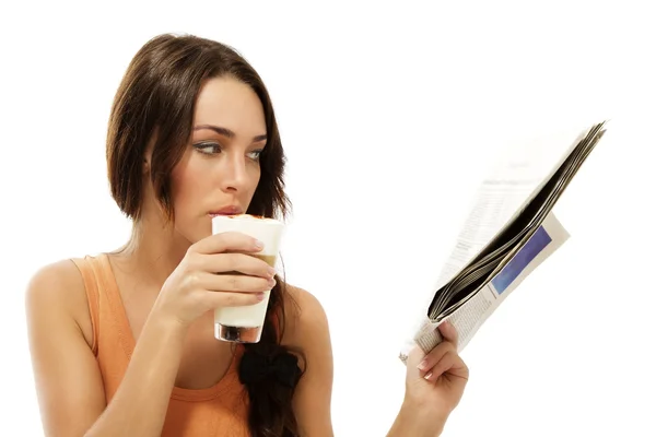 Красивая женщина пьет латте макиато читает газету — стоковое фото