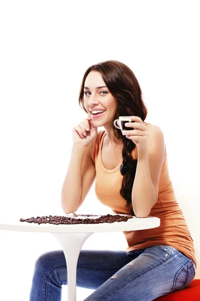 Gelukkige vrouw zittend op een tafel met espressokoffie — Stockfoto