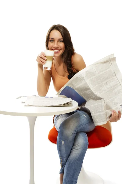 Happy young woman with latte macchiato coffee and a newspaper — Stock Photo, Image