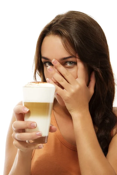 Mujer joven con latte macchiato escondiendo su cara con su mano — Foto de Stock