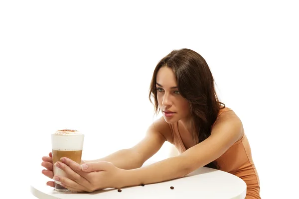 Mladá žena drží káva latte macchiato na druhé straně stolu — Stock fotografie