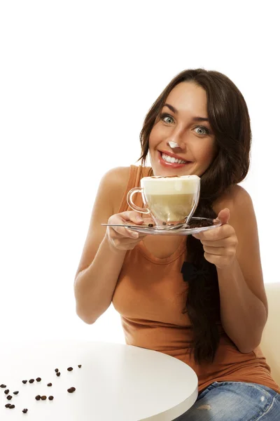 Ung kvinna med cappuccino kaffe har mjölk skum på näsan — Stockfoto