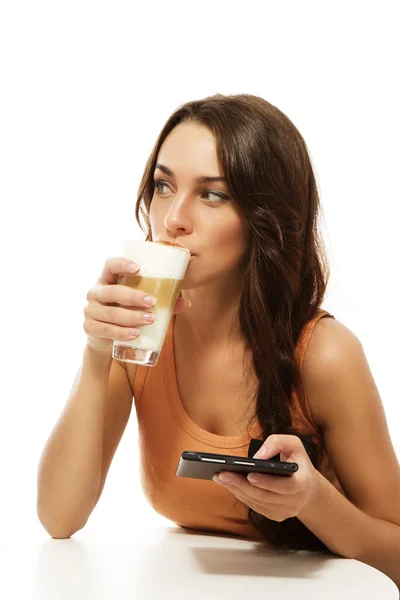 Bella donna che beve latte macchiato tenendo lettore ebook — Foto Stock