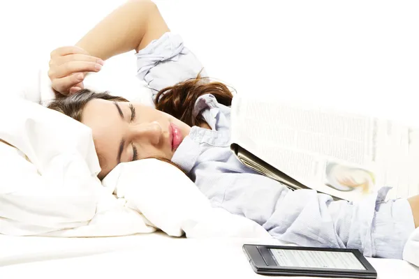 Vrouw voelde in slaap onder een krant met ebook reader opzij — Stockfoto