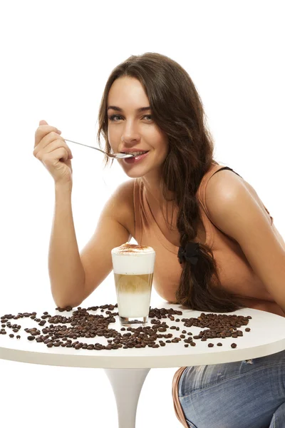 Piękna kobieta szczęśliwa przy stole z latte macchiato — Zdjęcie stockowe