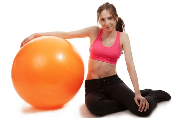 Jovem mulher esportiva com uma bola de fitness — Fotografia de Stock