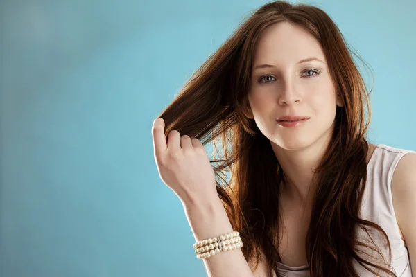 Ung kvinna som håller i håret — Stockfoto