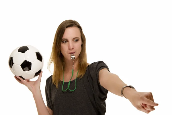 Mujer con un silbato sosteniendo una pelota de fútbol apuntando a algo —  Fotos de Stock