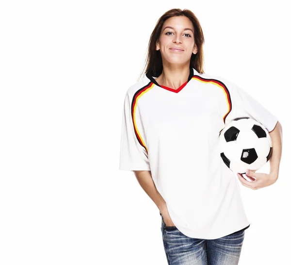 Mujer sonriente vistiendo camiseta de fútbol con fútbol bajo su brazo —  Fotos de Stock