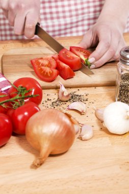 Closeup of hands cutting tomatoes clipart