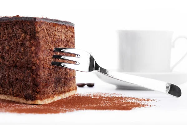 Torta al cioccolato con una forchetta e una tazza di caffè sullo sfondo — Foto Stock