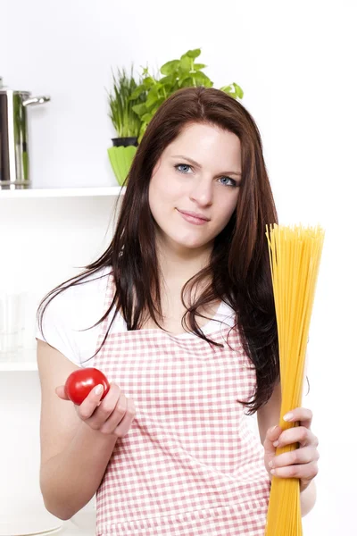Молодая женщина держит спагетти и помидоры — стоковое фото