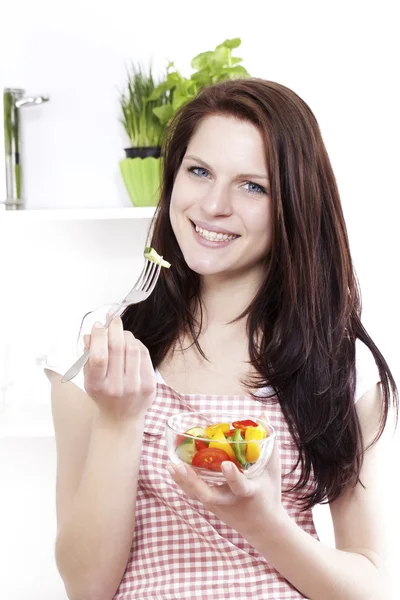 Jovem mulher comendo salada mista — Fotografia de Stock