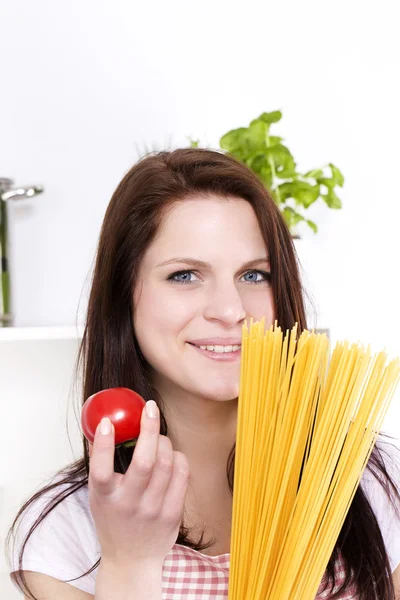 Portret van een jonge vrouw met pasta en tomaat — Stockfoto