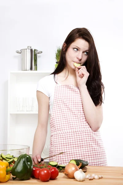 Jonge vrouw eten komkommer — Stockfoto