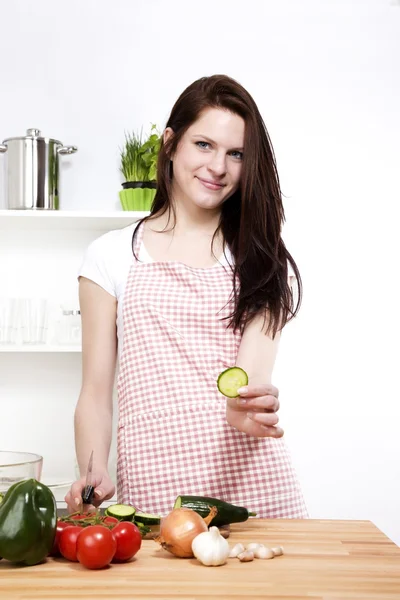 Jonge vrouw biedt een stukje komkommer — Stockfoto